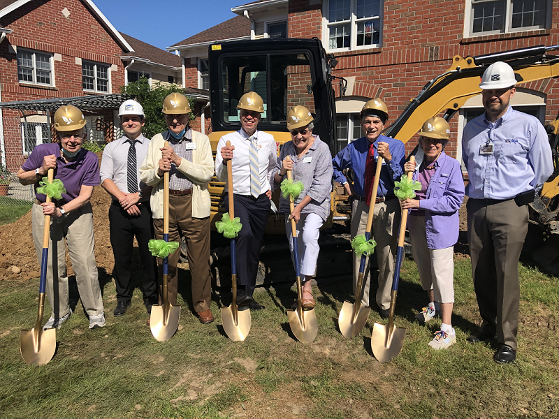 Members of The Highlands Resident Council and Executive Director Lloyd Theiss standing in a line holding shovels at the Memory Care Groundbreaking Ceremony