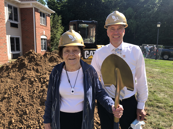 Resident and member of The Highlands Resident Council standing with shovel along with Executive Director Lloyd Theiss