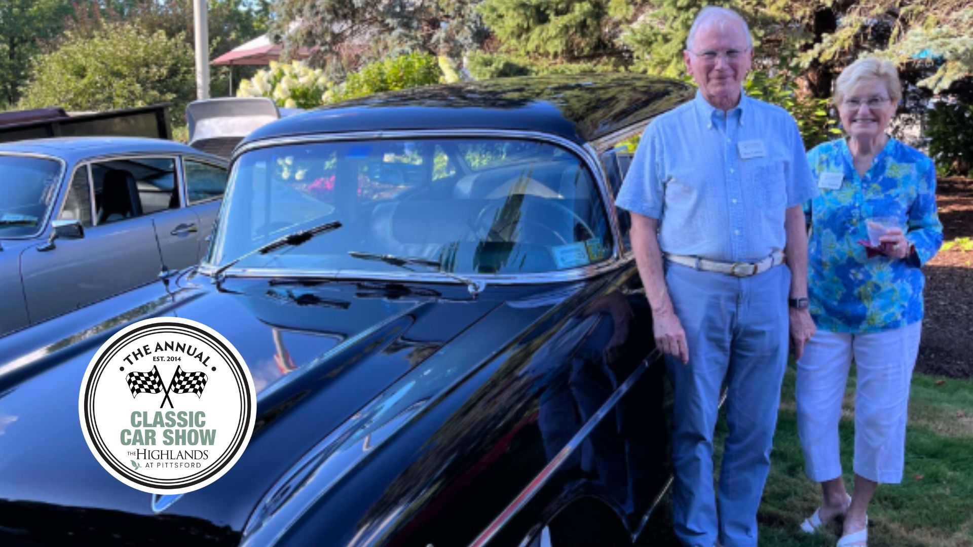 Residents standing next to vintage car