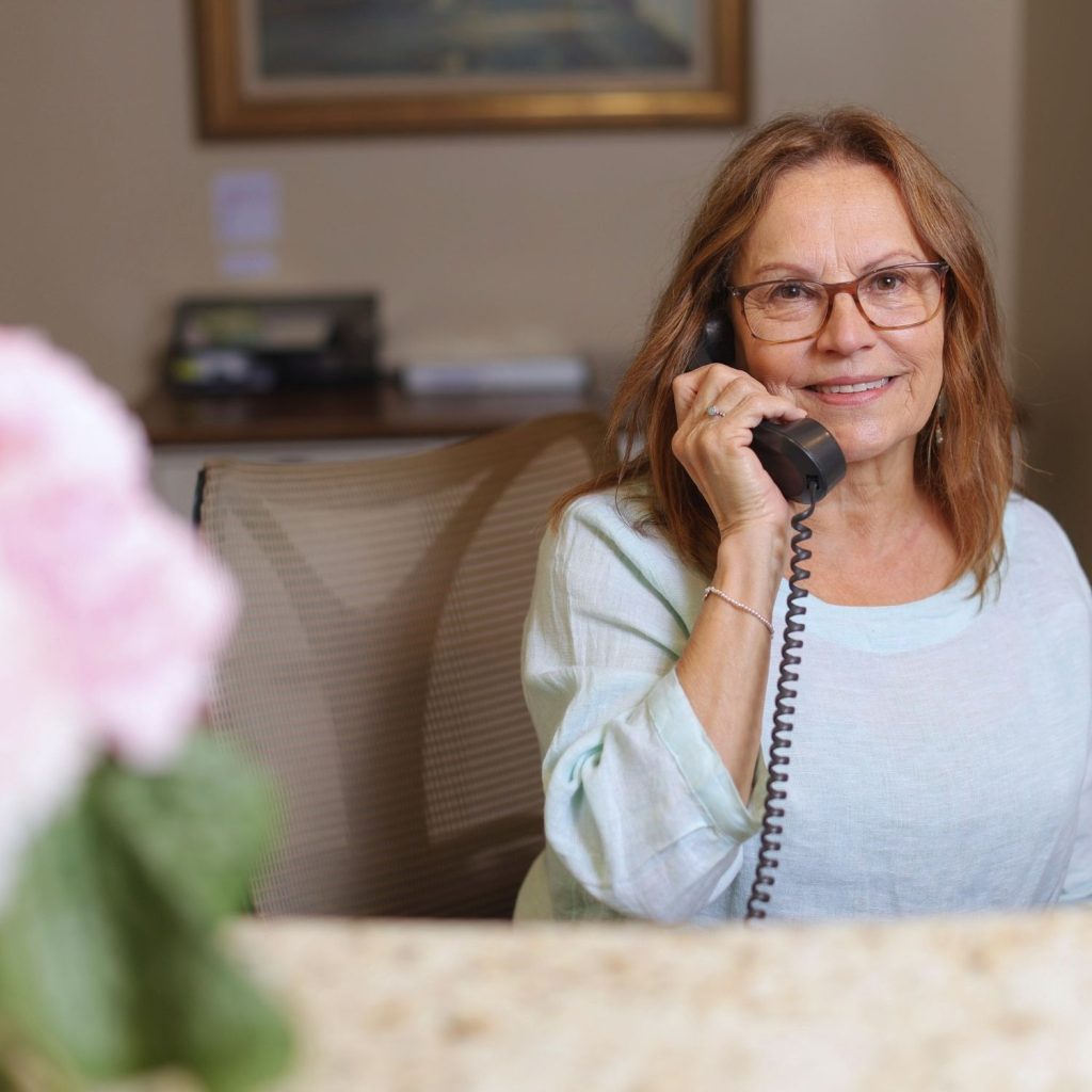 Employee greeting residents at the concierge desk in the Highlands entry