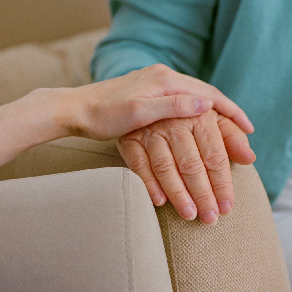 A caregiver touching a resident's hand