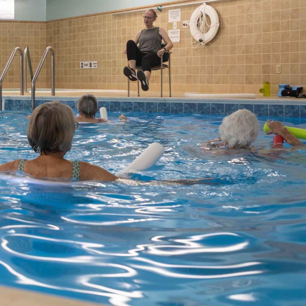 Residents guided by instructor in a swimming pool aquatic exercise class