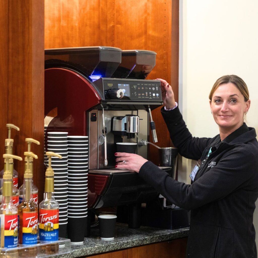 A woman serving coffee at the espresso bar